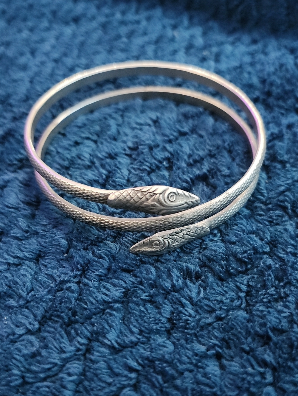 vintage-style oxidized silver snake bracelet is designed to coil around the arm.